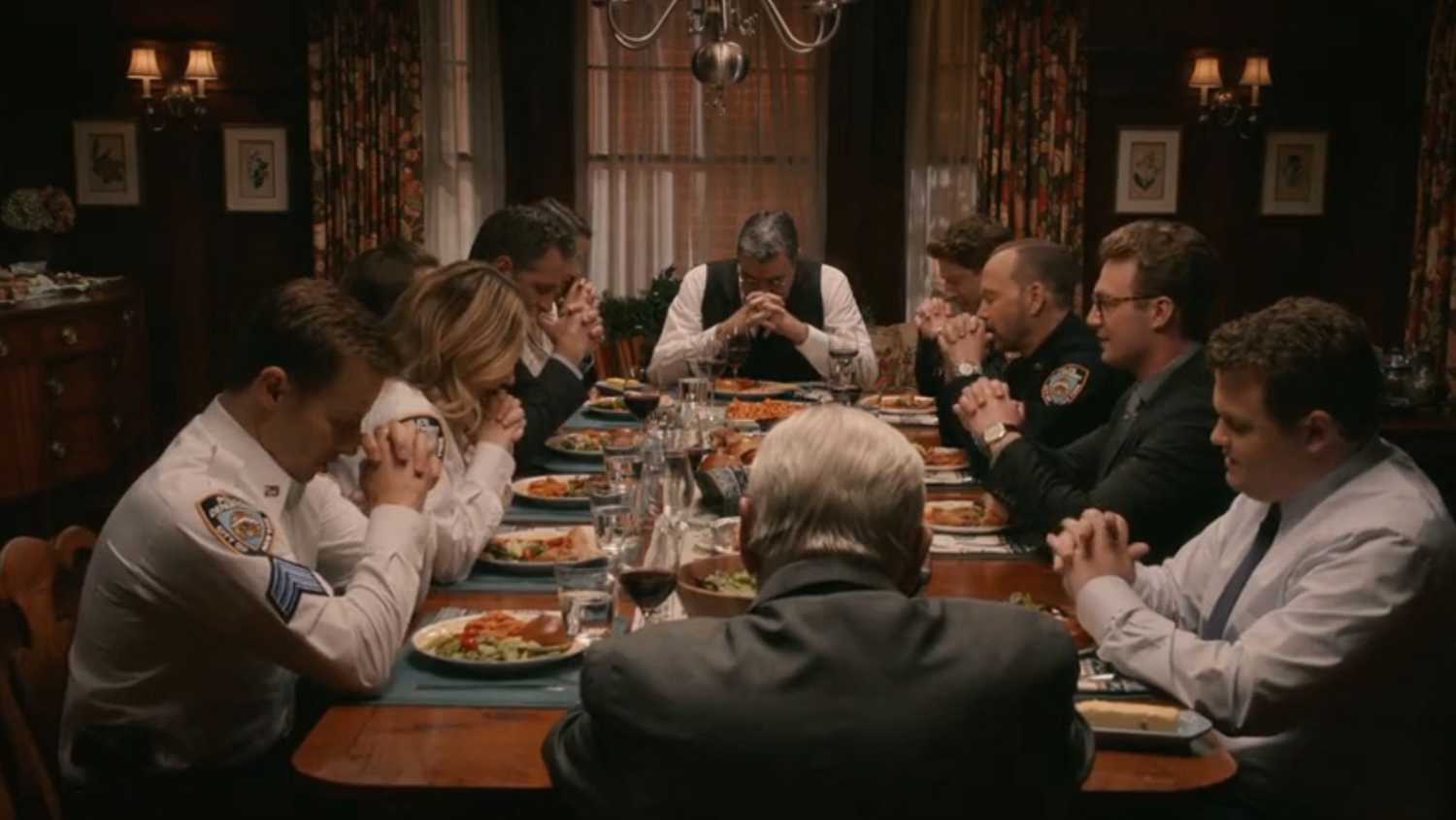 The Reagan family with heads bowed and hands clasped during the final dinner scene