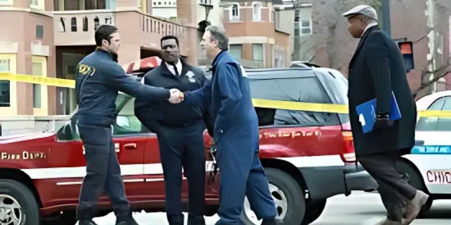 Boden watches while two men shake hands at a crime scene in Chicago FIre