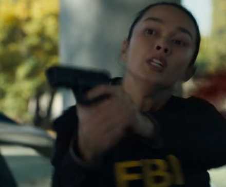 FBI: Inernational Vo holding her gun after she is hit