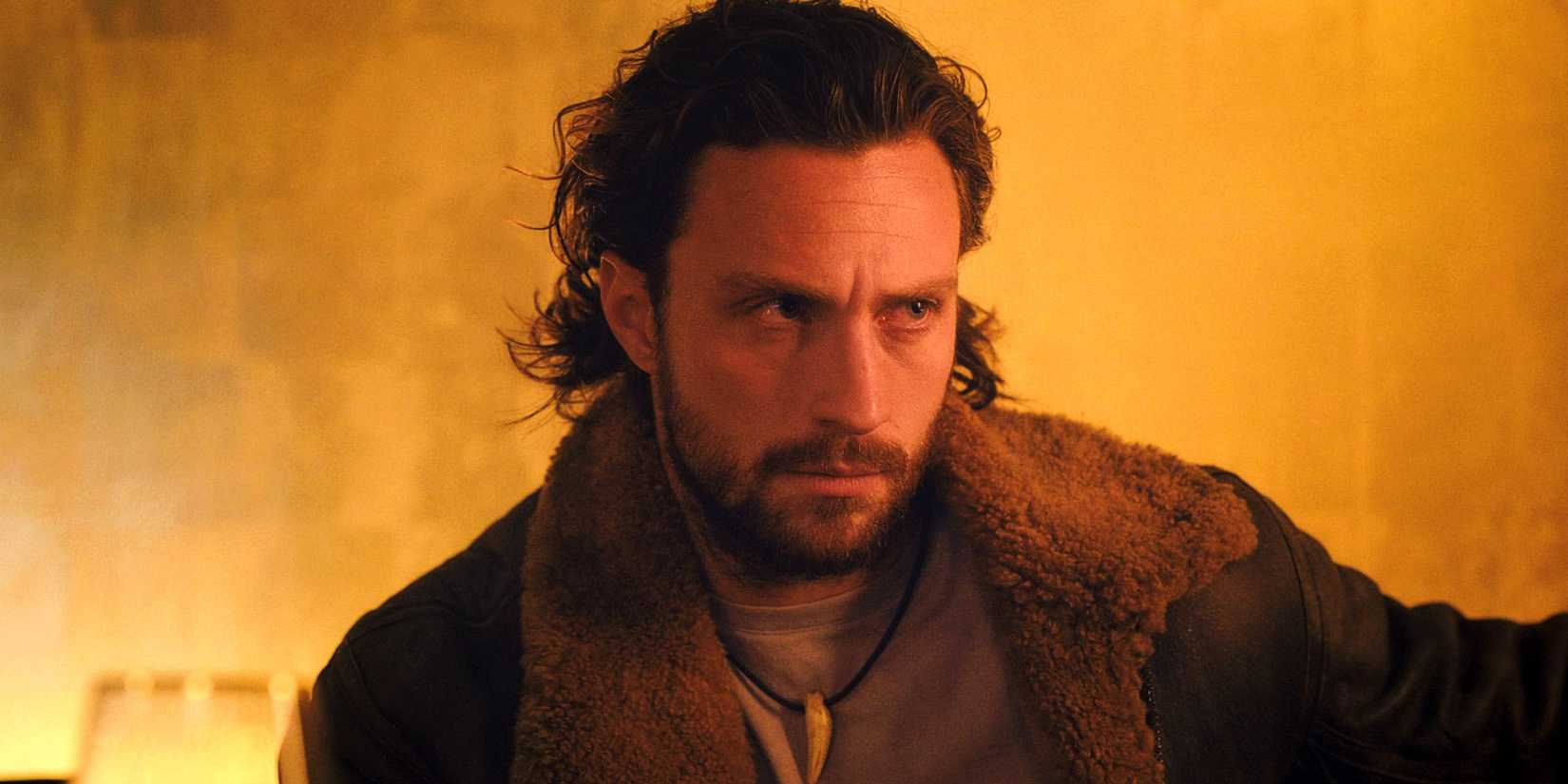 Aaron Taylor-Johnson as Sergei Kravinoff sitting in Dmitri's club in Kraven the Hunter