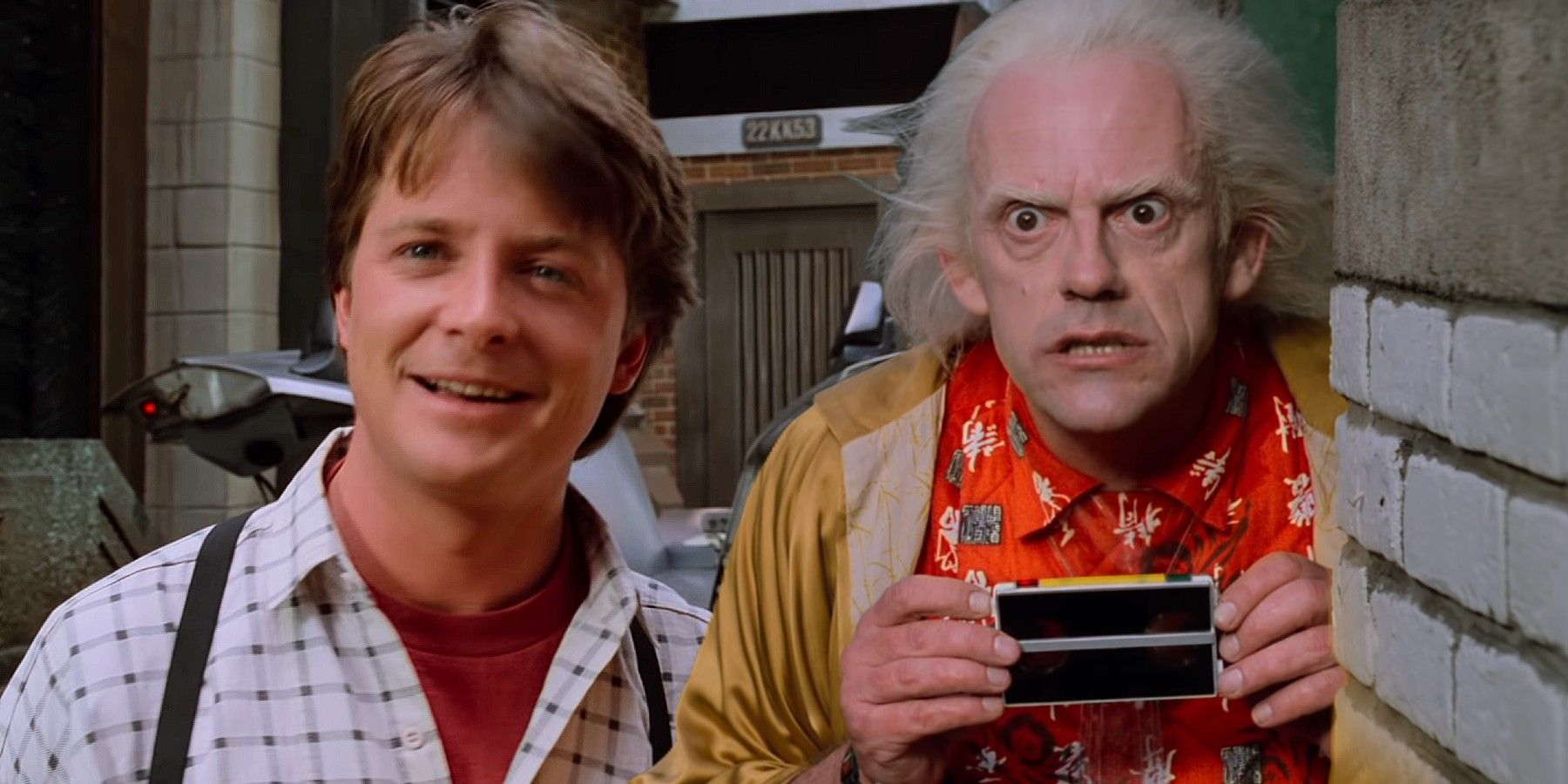 Marty McFly (Michael J. Fox) smiling and Doc Brown (Christopher Lloyd) looking horrified in Back to the Future Part II