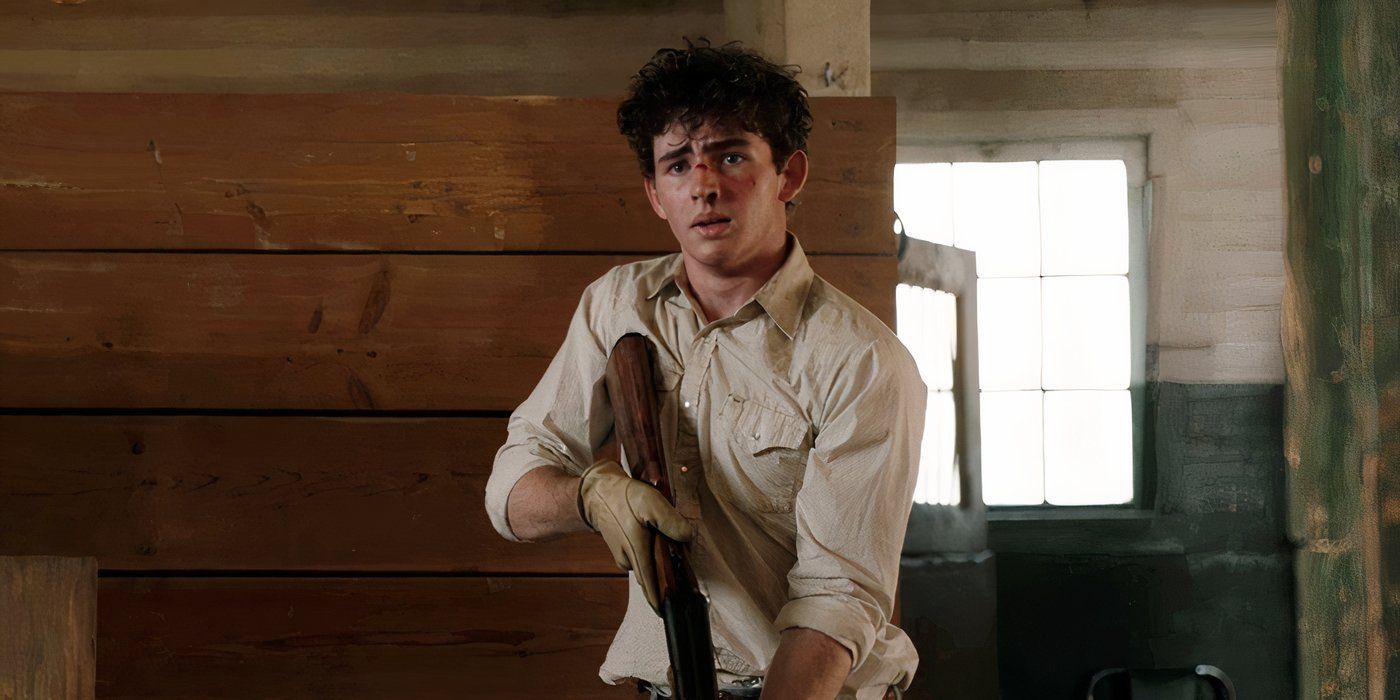 Finn Little as Carter in Yellowstone season 5 episode 12, holding a gun to shoot a violent horse