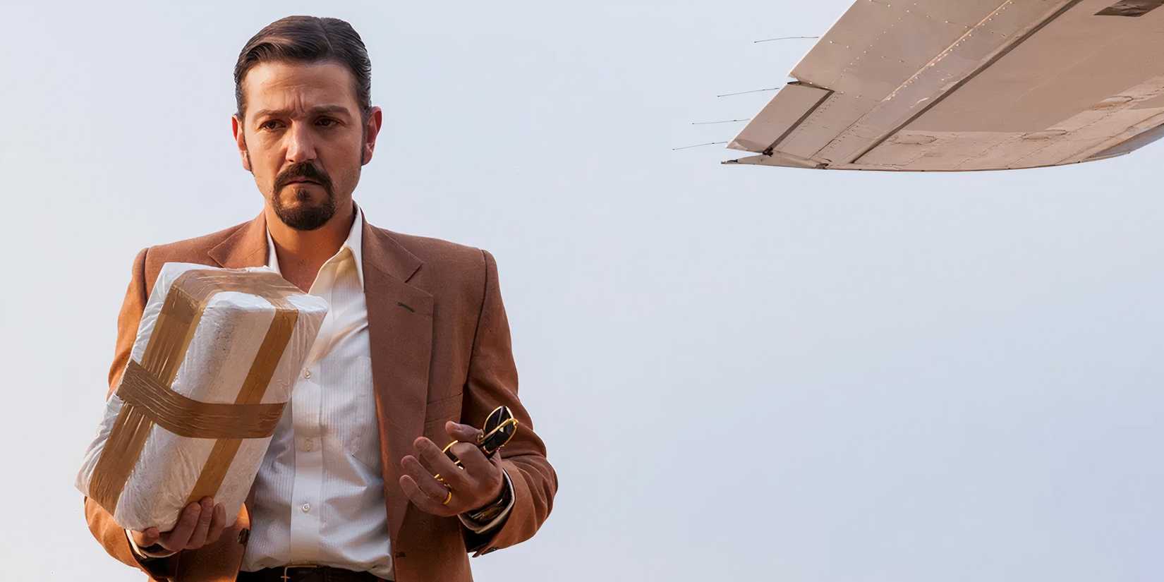 Felix Gallardo (Diego Luna) holding a wrapped package of cocaine in Narcos Mexico
