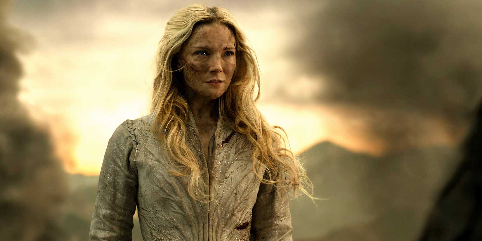 morfydd clark s galadriel cut up and looking intensely at charlie vickers sauron with a cliff behind her in the lord of the rings the rings of power season 2 finale