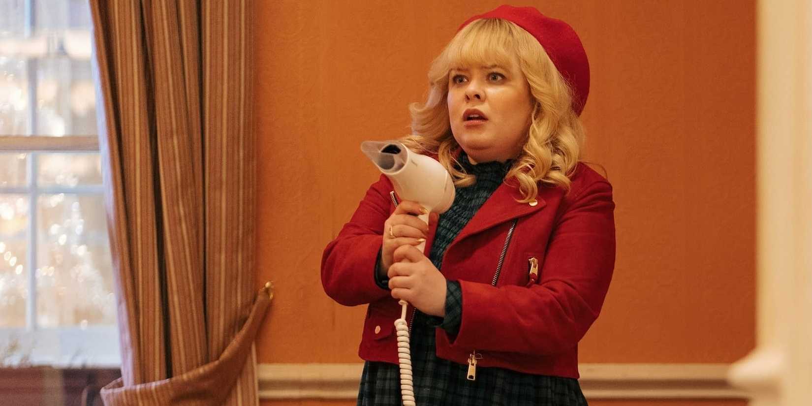 Nicola Coughlan as Joy holding a hair dryer like a gun in Doctor Who Christmas Special
