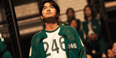 Gyeong-seok looking up while wearing his Player 246 jacket in Squid Game season 2