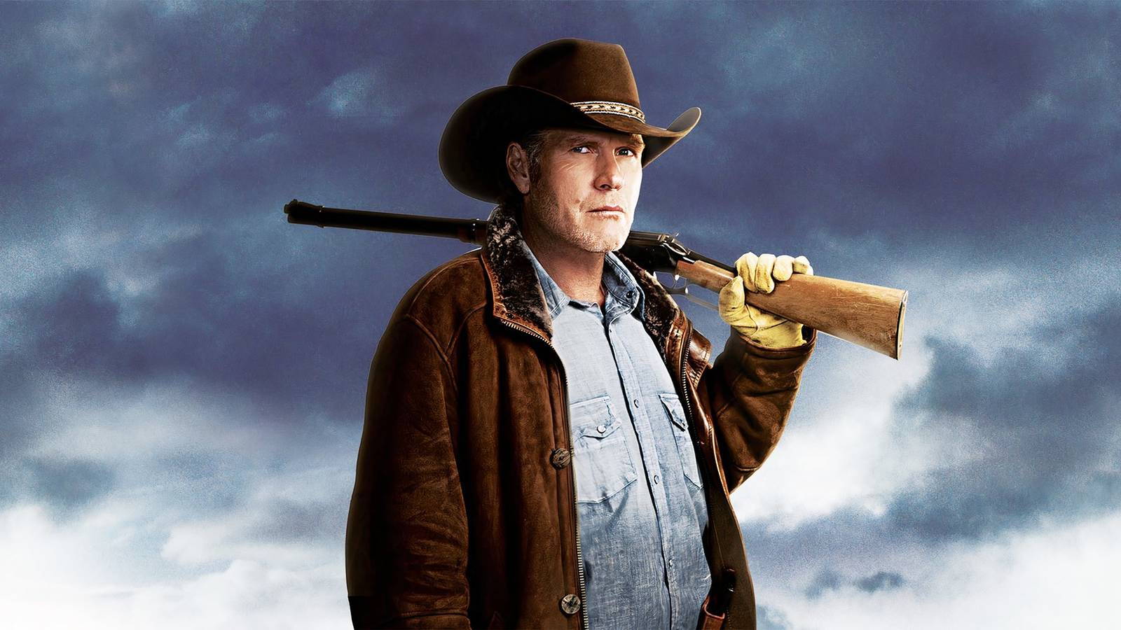 Robert Taylor posing as the lead character of Longmire, against a blue backdrop