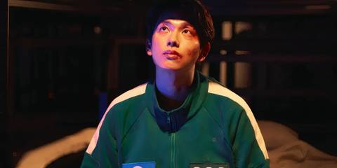 Myung-gi looking up in his green jumpsuit in Squid Game