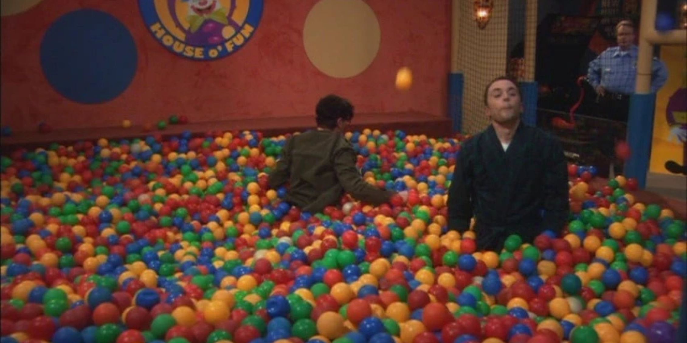 The Big Bang Theory Sheldon standing in a ball pit while Leonard tries to run after him