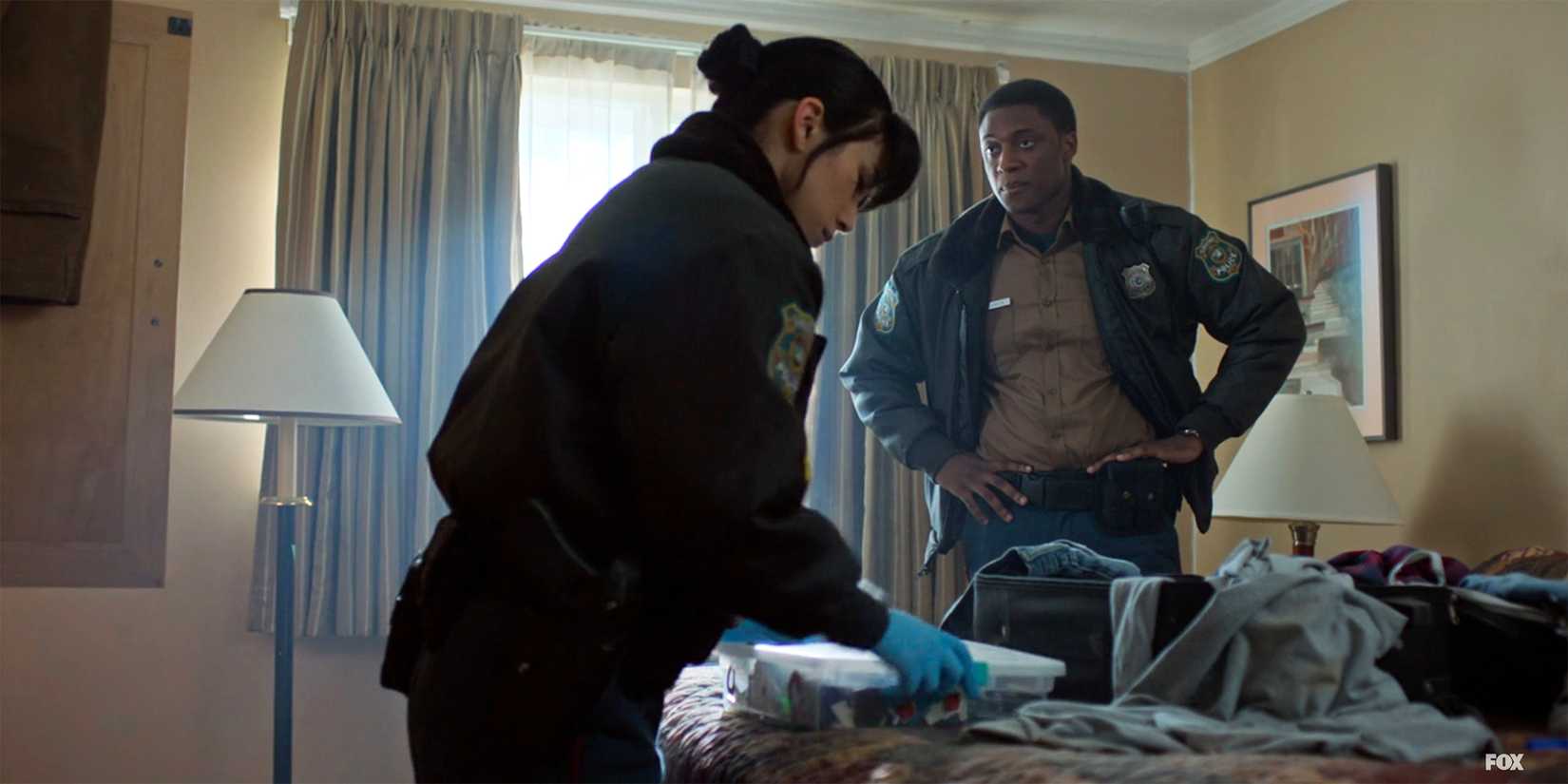 Yen and Andy investigate a hotel room in Murder in a Small Town