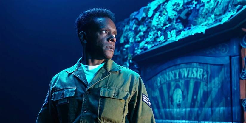 A soldier stands in front of an image of Pennywise the Dancing Clown in Welcome to Derry