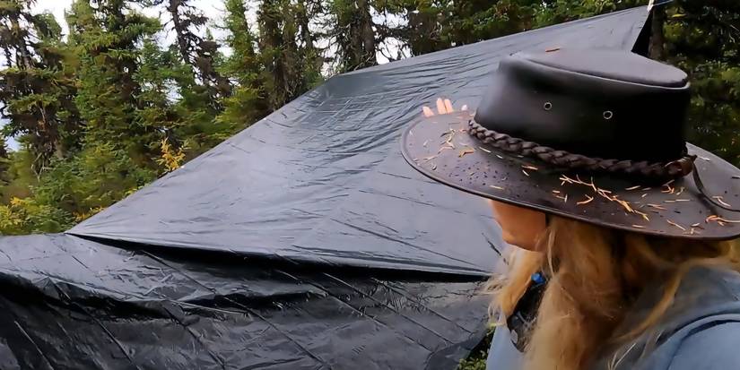 competidor da temporada 9 de Alone em uma tenda.