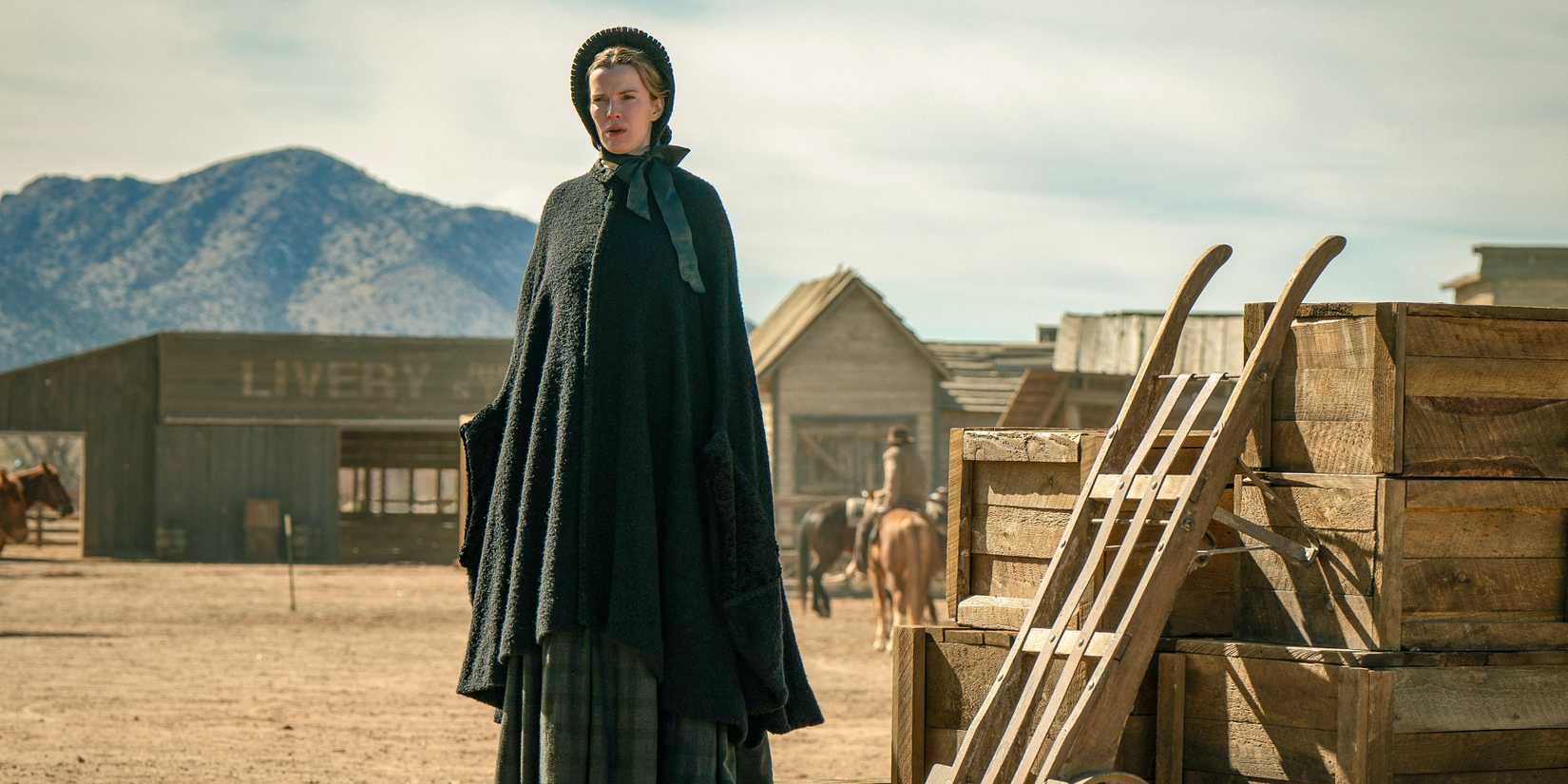 Betty Gilpin standing next to wooden crates as Sara in American Primeval