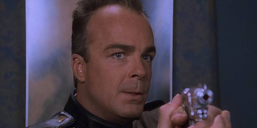 Michael Garibaldi (Jerry Doyle) em Babylon 5, empunhando uma arma.