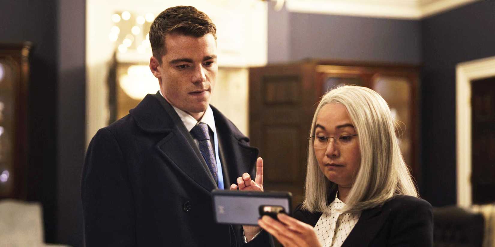 Diane (Hong Chau) showing Peter (Gabriel Basso) a video in The Night Agent season 1, episode 1