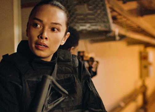 Cameron Vo holding a gun in FBI: International season 4, episode 2