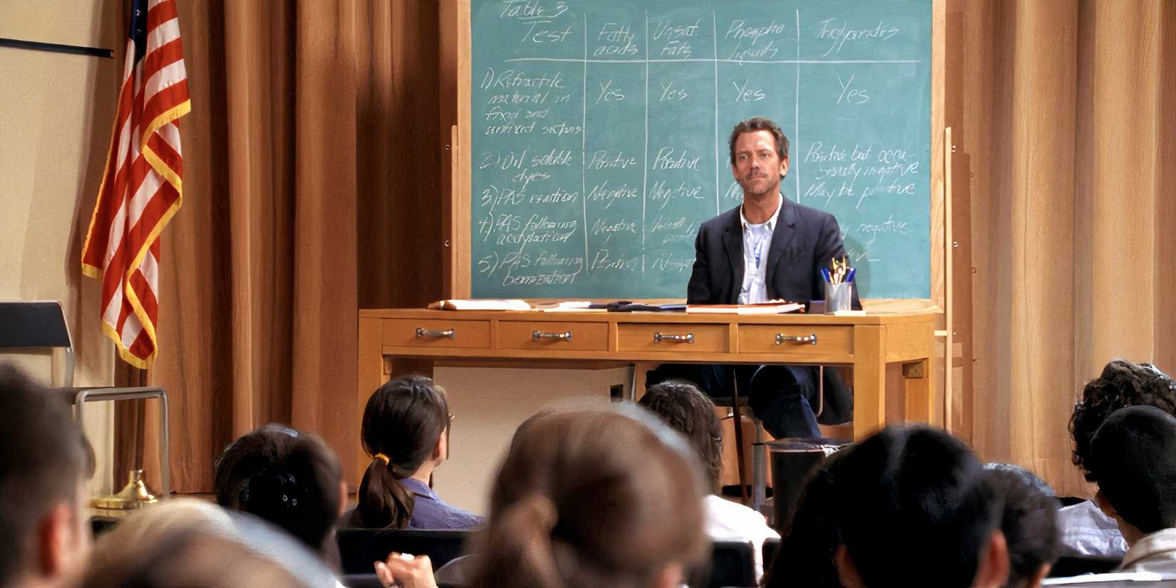 House dando uma palestra para uma sala cheia de estudantes, em frente a um quadro negro, no episódio de House 'Three Stories'.