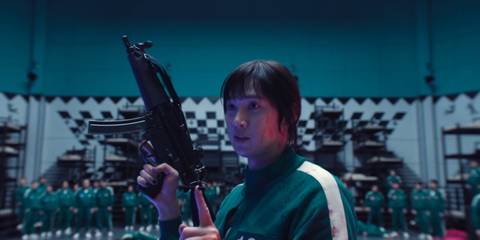Hyun-ju (Park Sung-hoon) shows the players how to use firearms in Squid Game 