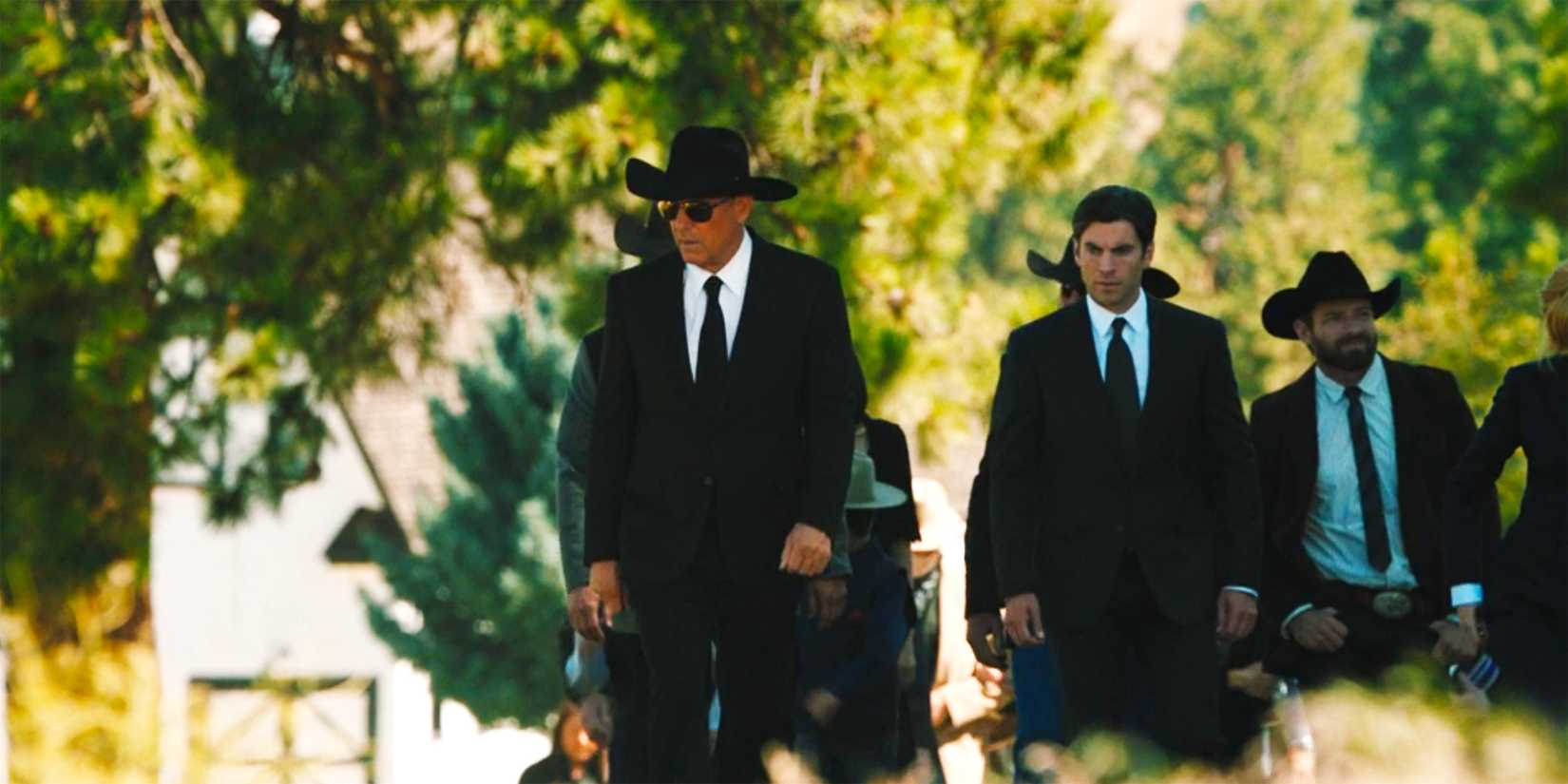 John walking with a funeral procession after Lee Dutton's funeral in Yellowstone