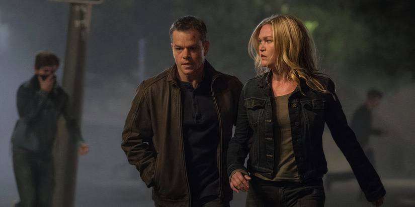 Matt Damon and Julia Stiles walk next to each other looking alert in Jason Bourne