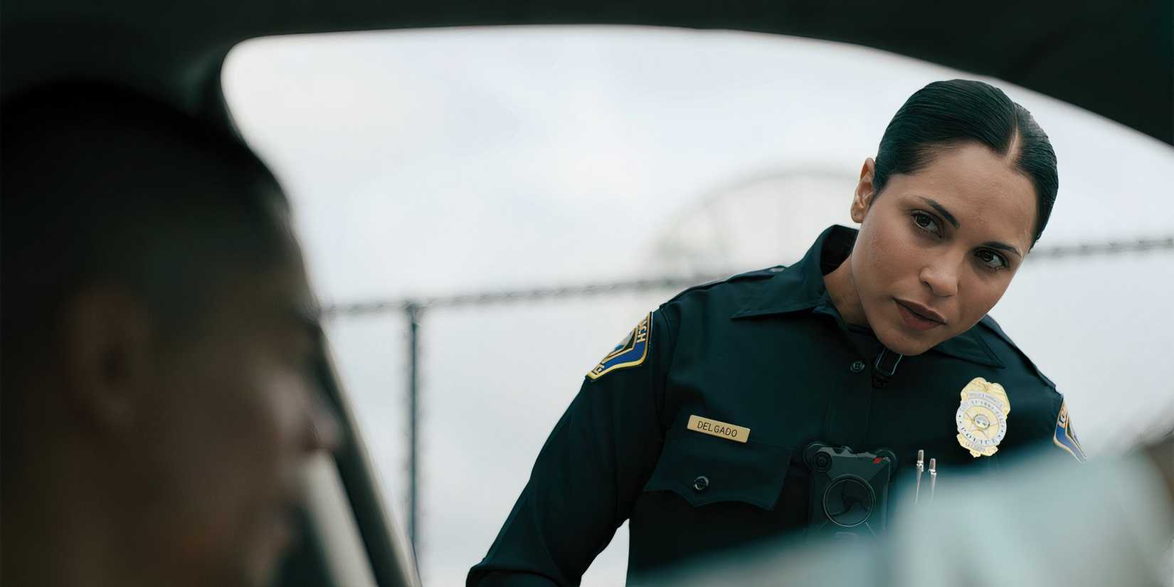 Monica Raymund as Delgado looking worried into a car during a traffic stop in On Call