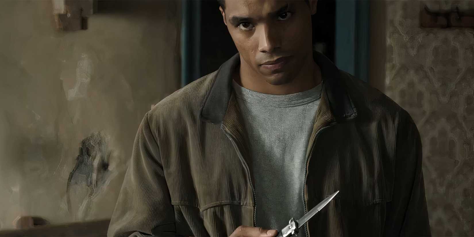 Ром Флинн в роли Фрэнка Лукаса в 4-м сезоне "Godfather of Harlem", держащий нож