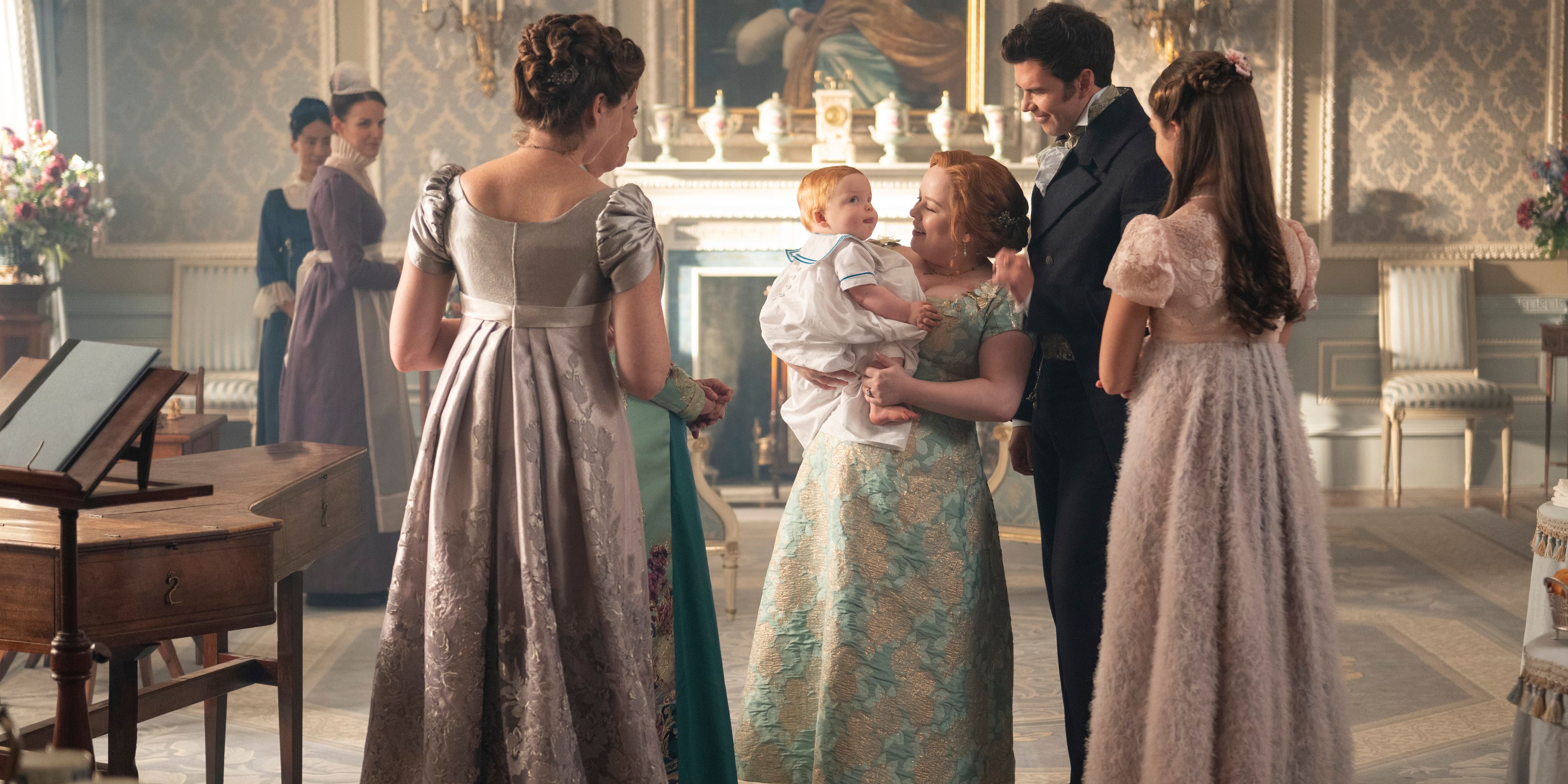 Violet Bridgerton (Ruth Gemmell), Portia Featherington (Polly Walker), Penelope Featherington (Nicola Coughlan), Colin Bridgerton (Luke Newton), & Hyacinth Bridgerton (Florence Hunt) Admiring Colin & Penelope's Baby In Bridgerton Season 4, Episode 1