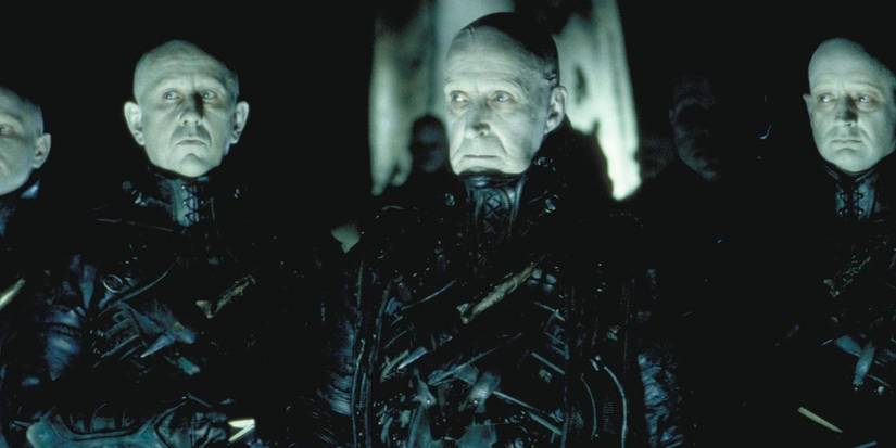 Os Estranhos parados nas sombras em Dark City.