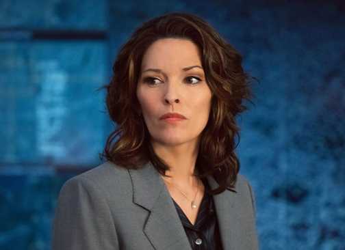 FBI Isobel standing in front of a blue map looking upset