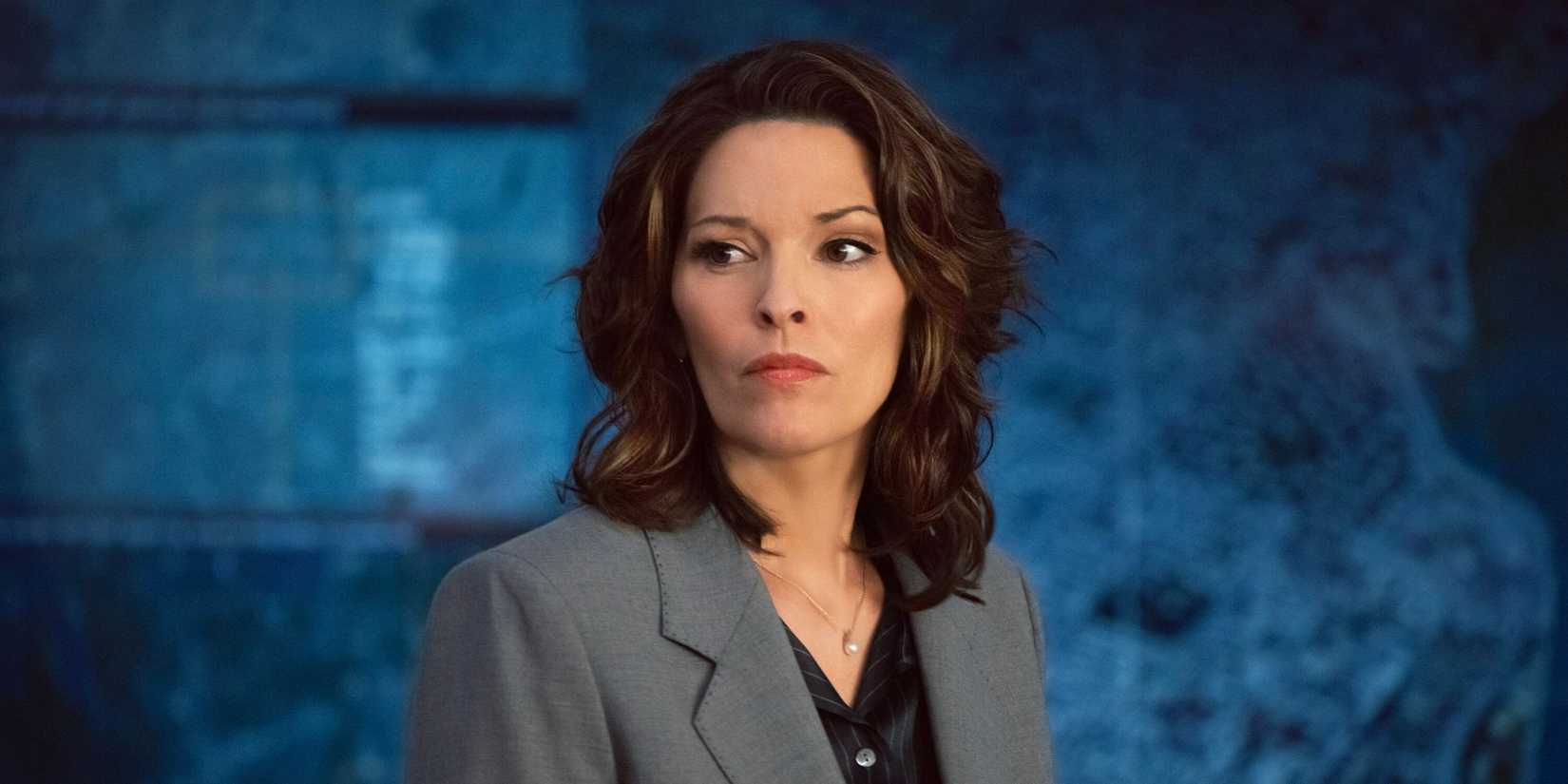 FBI Isobel standing in front of a blue map looking upset