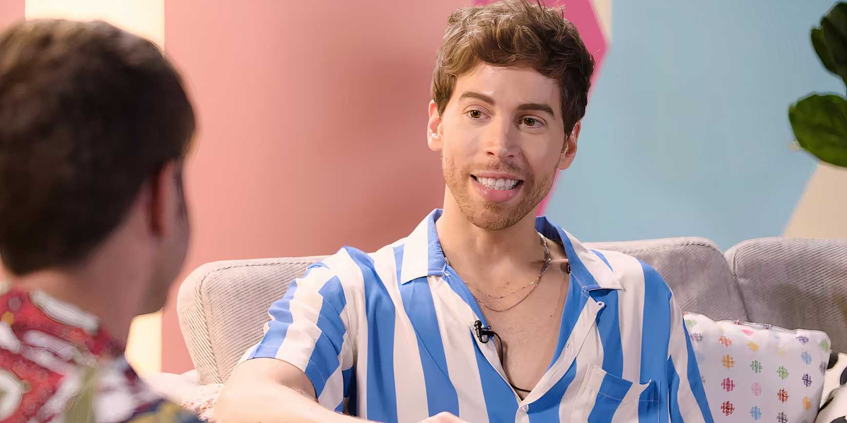 The Cast Of New Horror Movie Touch Me Explain Their Surprisingly Emotional Film About A Sexy Alien 4 Jordan Gavaris smiling and sitting on a couch in The Lake