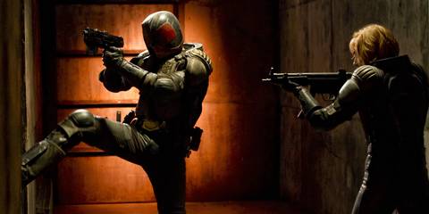 Judge Dredd kicks down a door next to Judge Anderson in Dredd