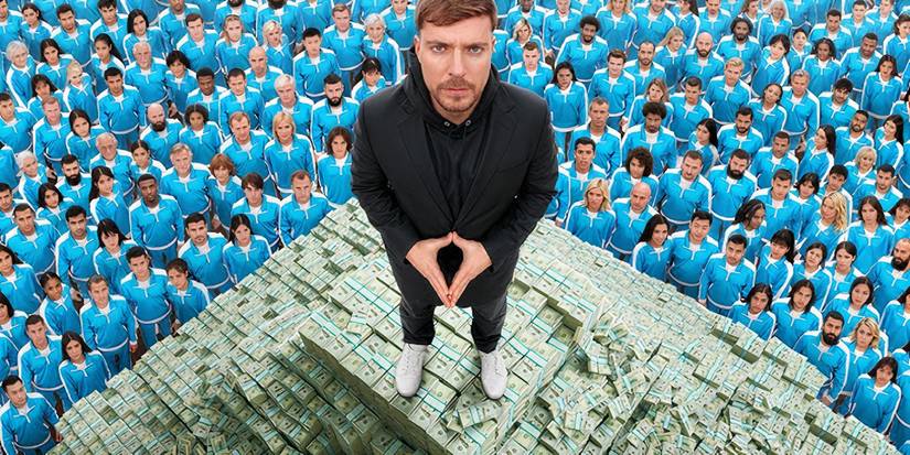 MrBeast in einer schwarzen Jacke lächelt vor einer Gruppe von Teilnehmern.