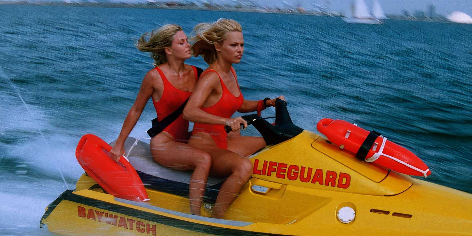Nicole Eggert as Summer Quinn and Pamela Anderson as C.J. Parker riding a jetski in Baywatch.