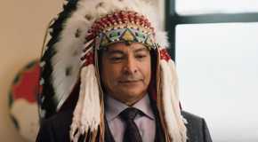 Thomas Rainwater adorned in a Native American headdress in Yellowstone