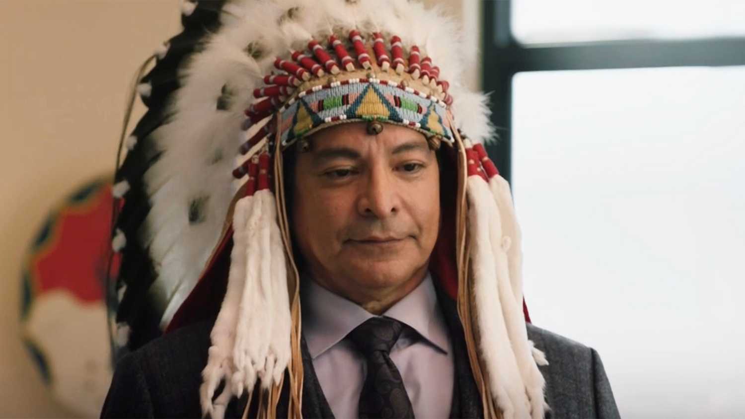 Thomas Rainwater adorned in a Native American headdress in Yellowstone