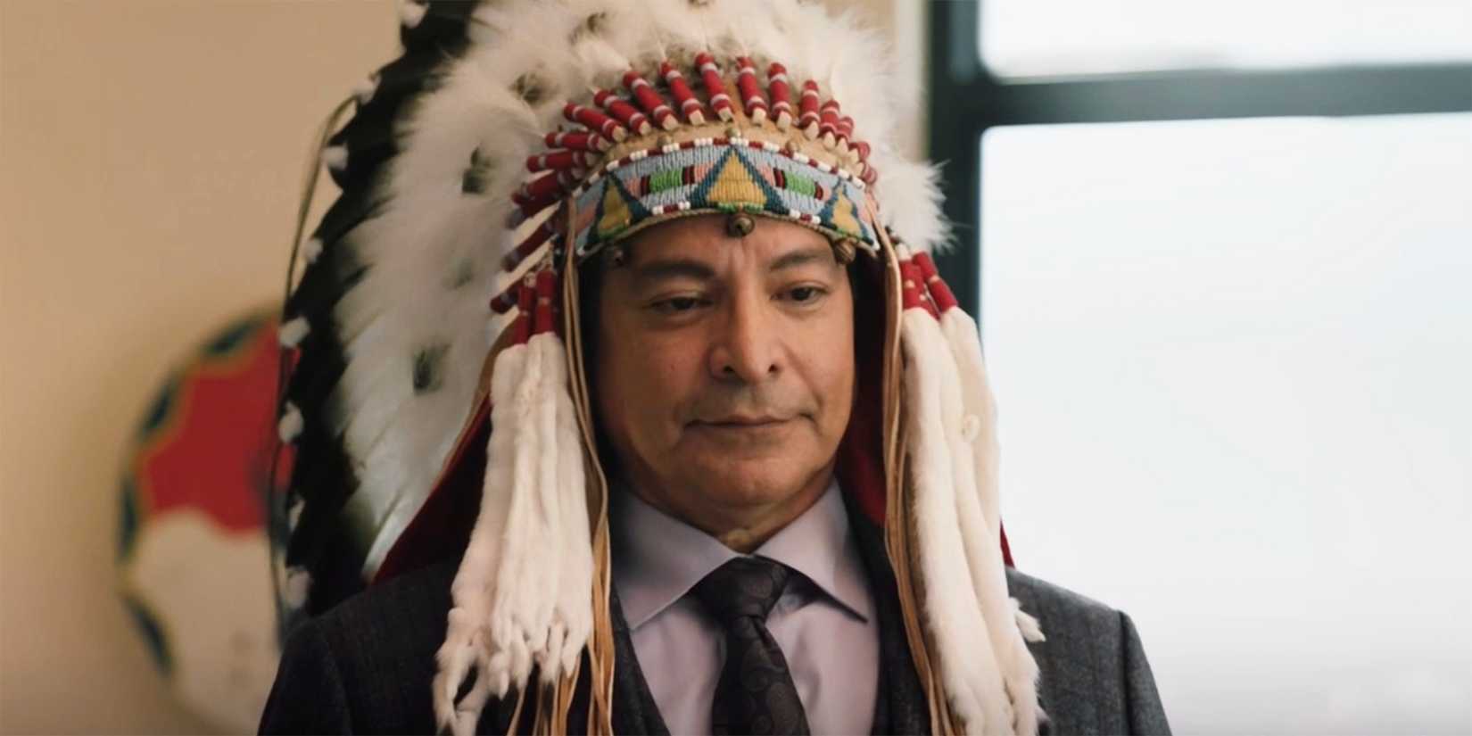 Thomas Rainwater adorned in a Native American headdress in Yellowstone