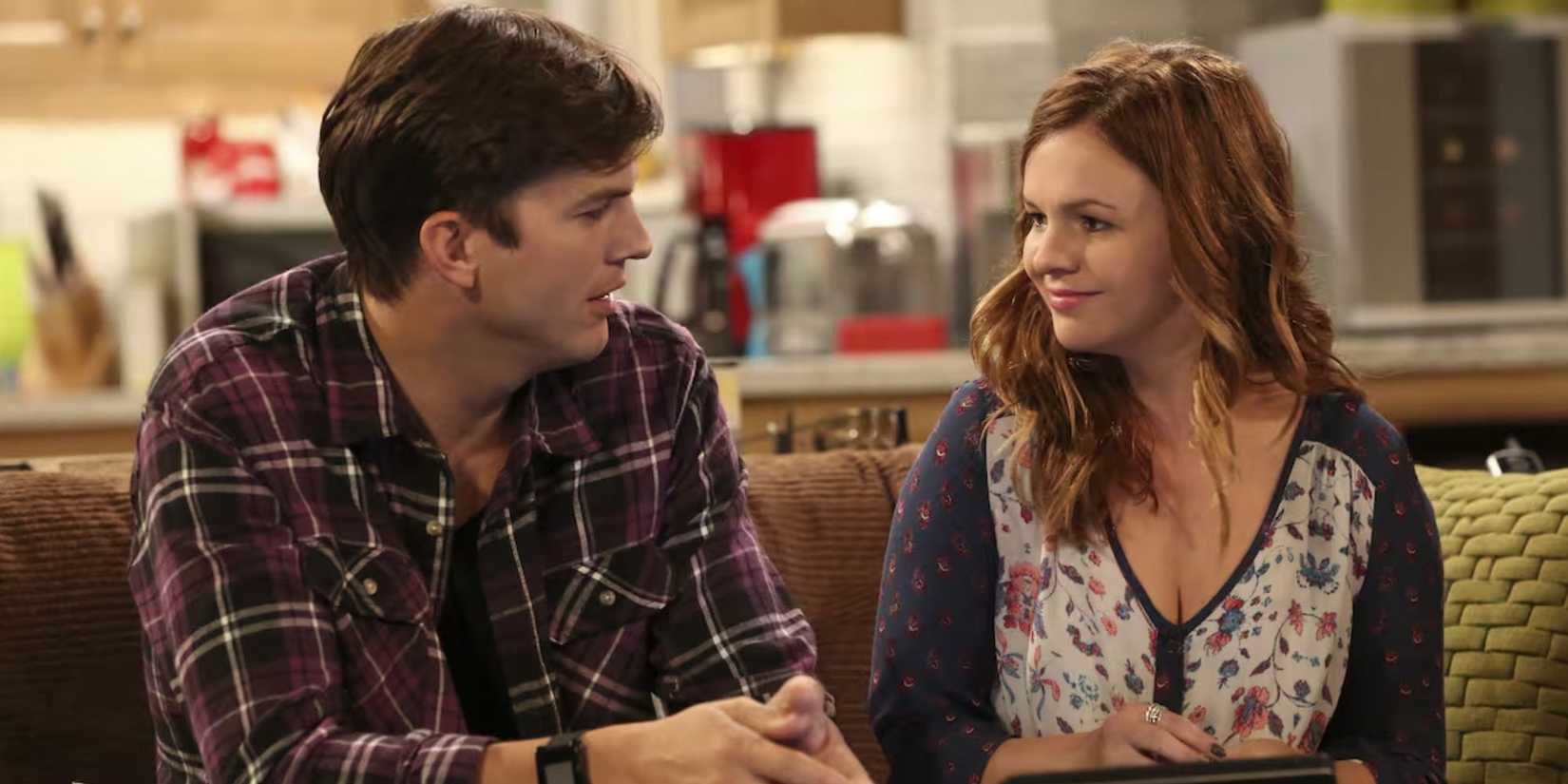 Amber Tamblyn sorrindo como Jenny Harper em Two and a Half Men com Ashton Kutcher como Walden Schmidt ao seu lado.