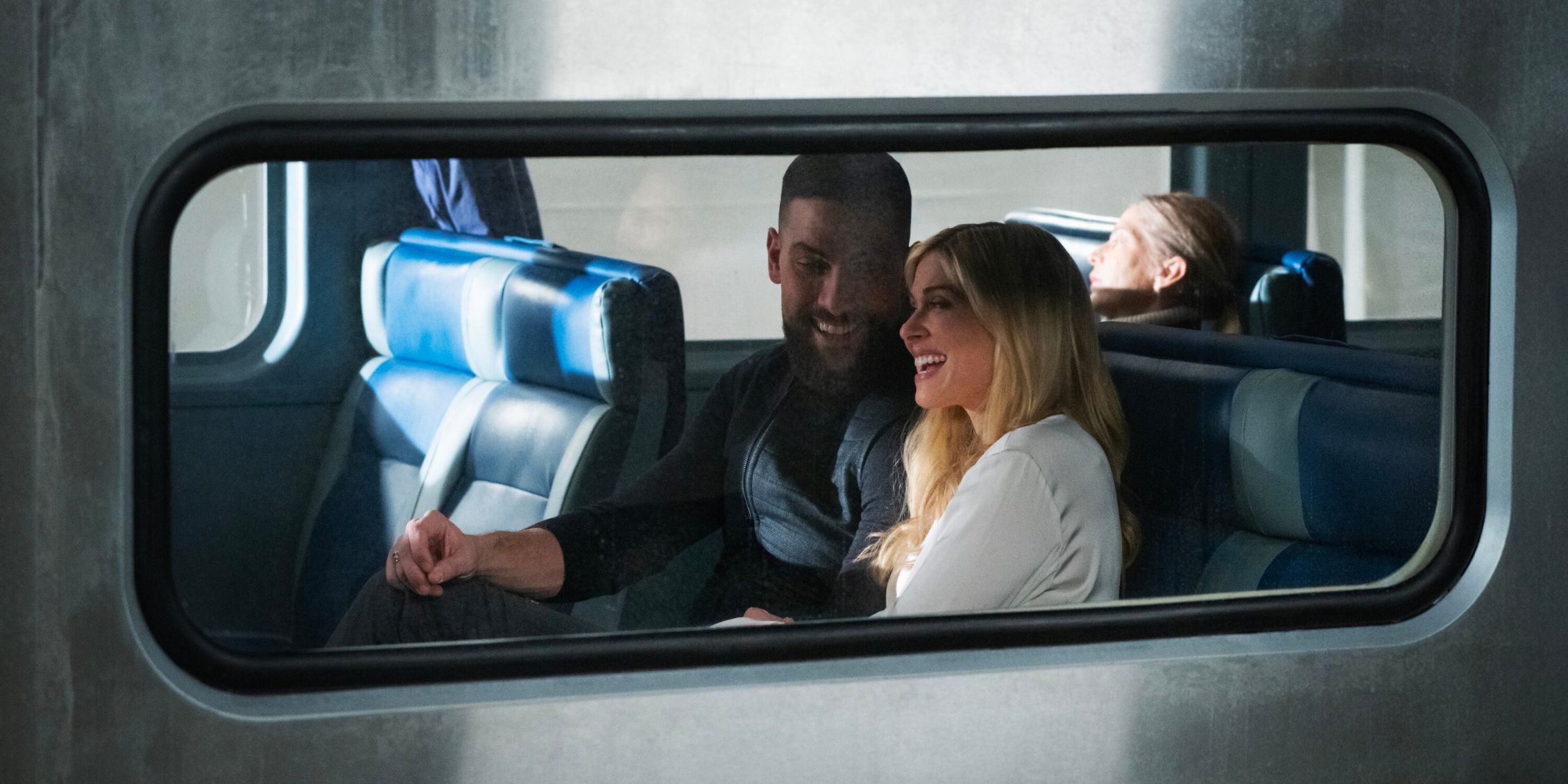 FBI OA and Gemma sitting together, seen through the train window