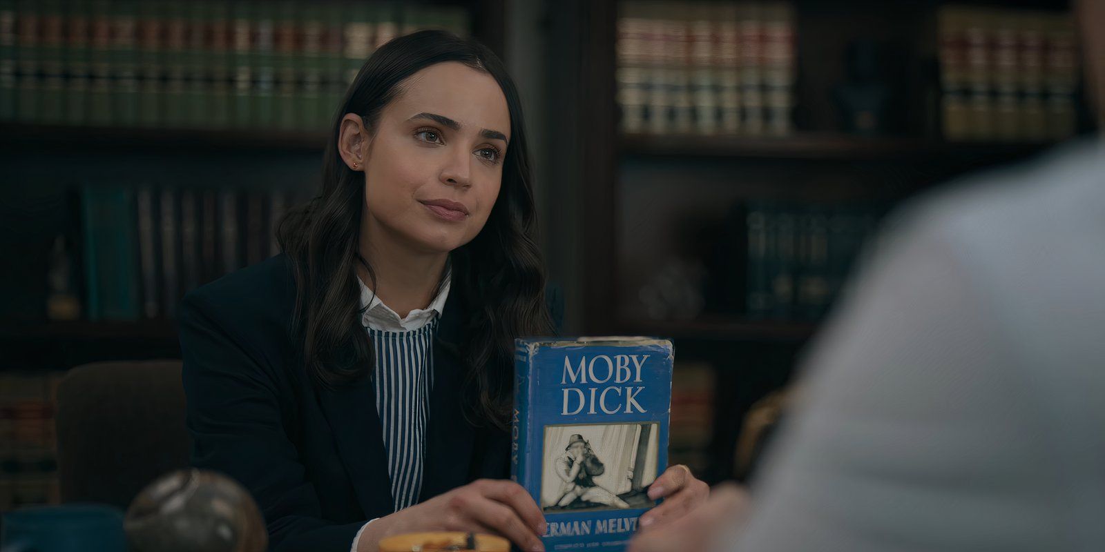 Alex holds up the book Moby Dick in The Life List