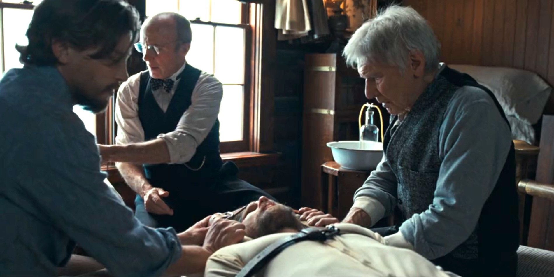 Jack (Darren Mann) and Jacob Dutton (Harrison Ford) hold Zane Davis (Brian Geraghty) in place as Dr. Miller (Mark Daneri) drills into his head in 1923 season 2, episode 4