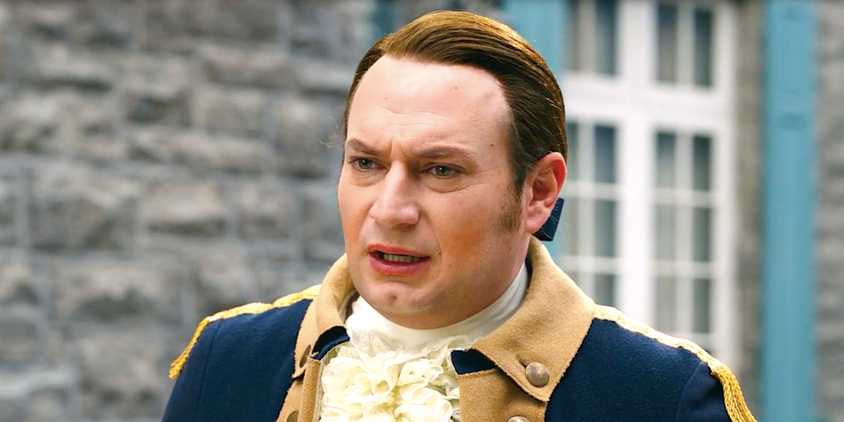 Brandon Scott James' Isaac looks concerned standing outside the mansion in Ghosts season 4 episode 16