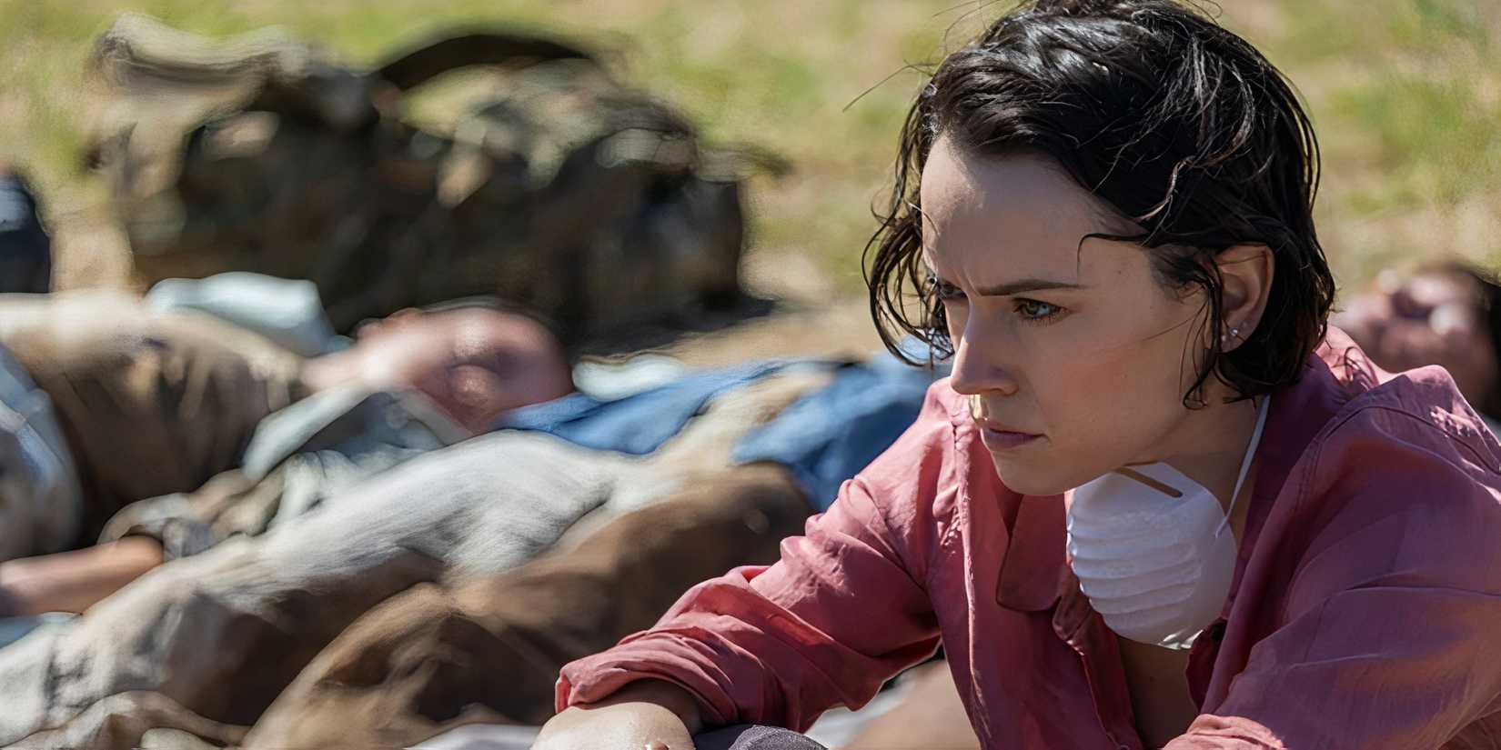 Daisy Ridley as Ava looking upset while sitting next to dead bodies in We Bury the Dead