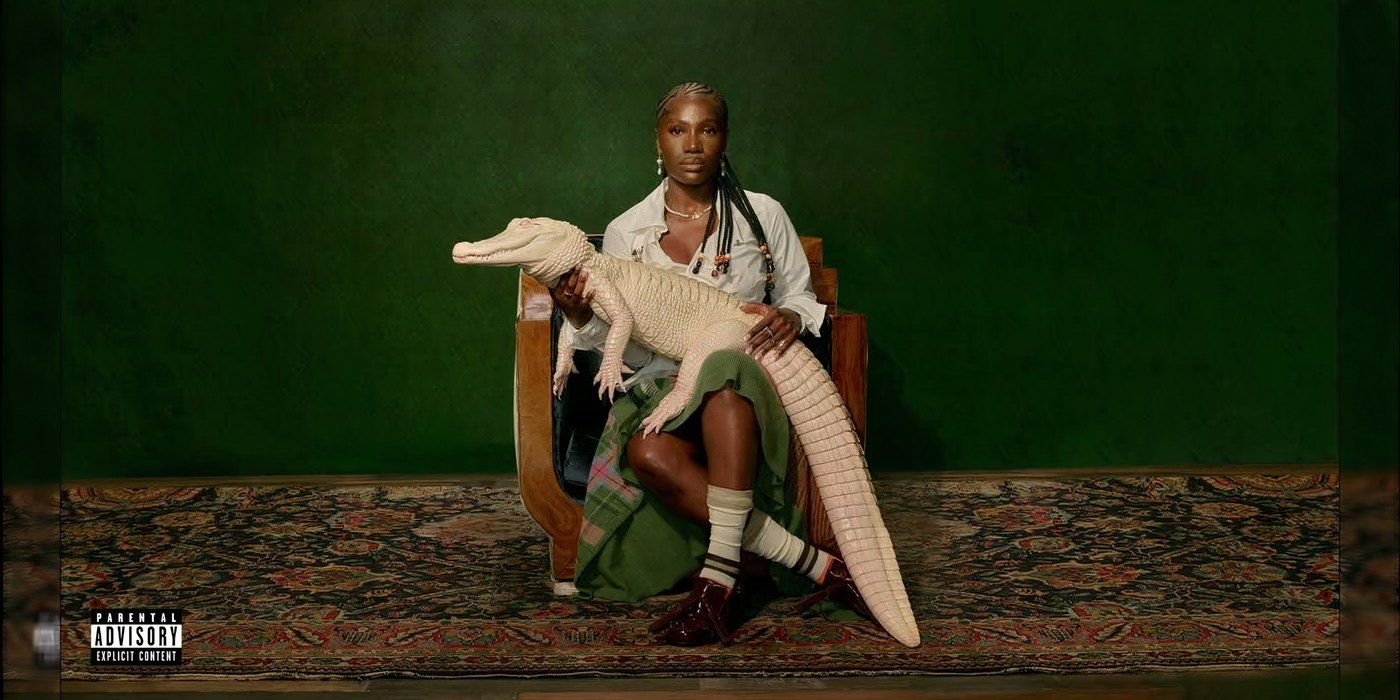 This album cover features a woman holding a white alligator against a green background while sitting in a chair on a carpeted floor. She's wearing a green dress with a white shirt, white socks, and dark shoes.