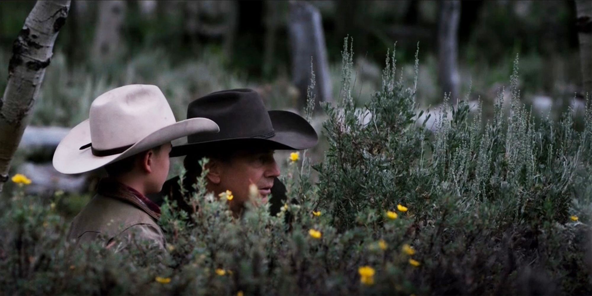 John and Tate crouched in the sage brush