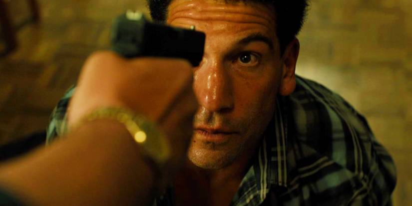 Jon Bernthal no chão com uma arma apontada para ele em Sicario