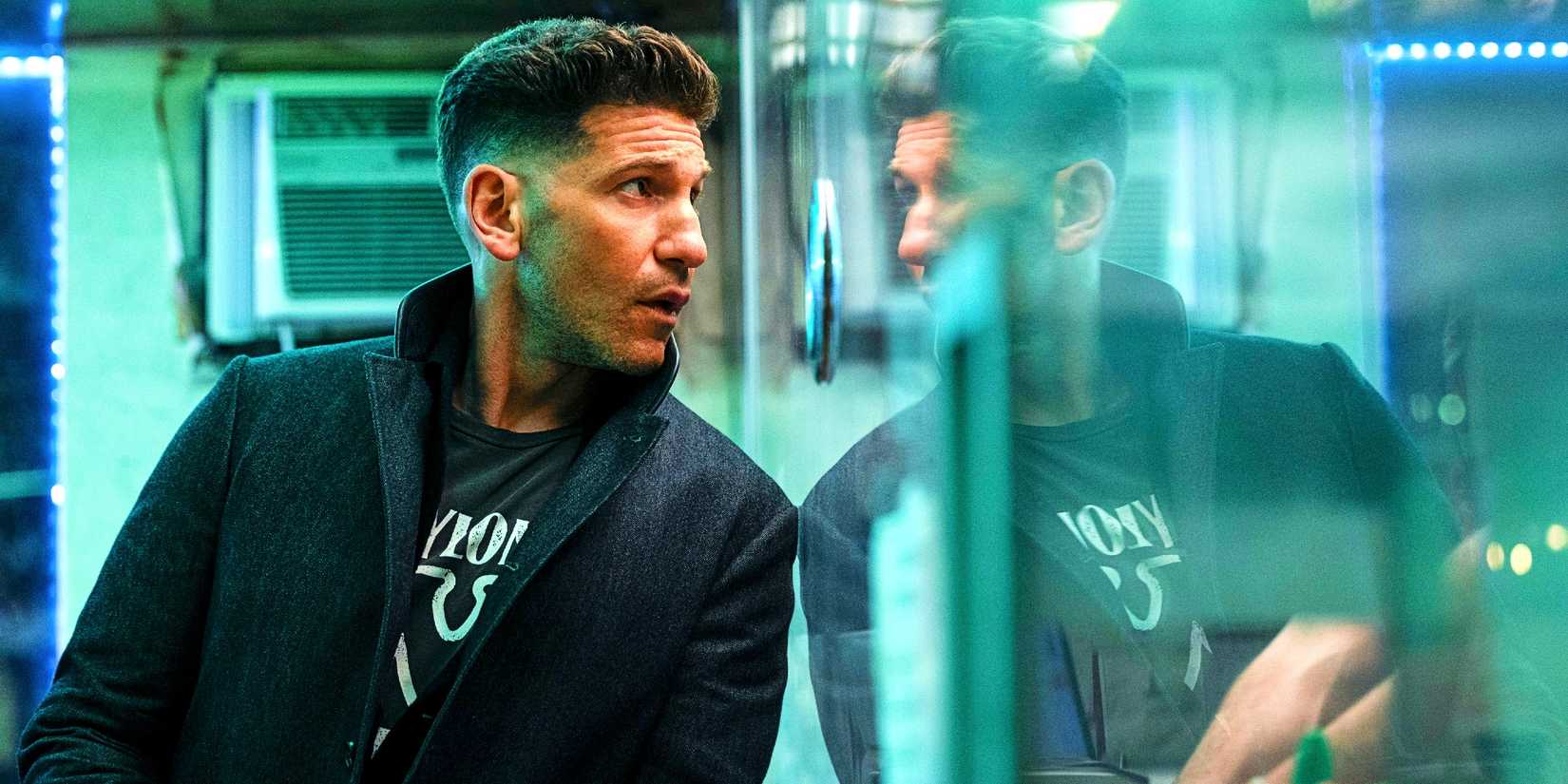 Jon Bernthal talks to a hotel attendant through a paritition in The Accountant 2