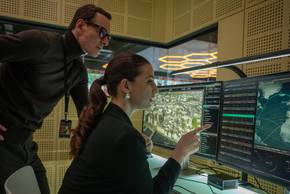 Michael Fassbender looks at a computer with Marisa Abela in Black Bag