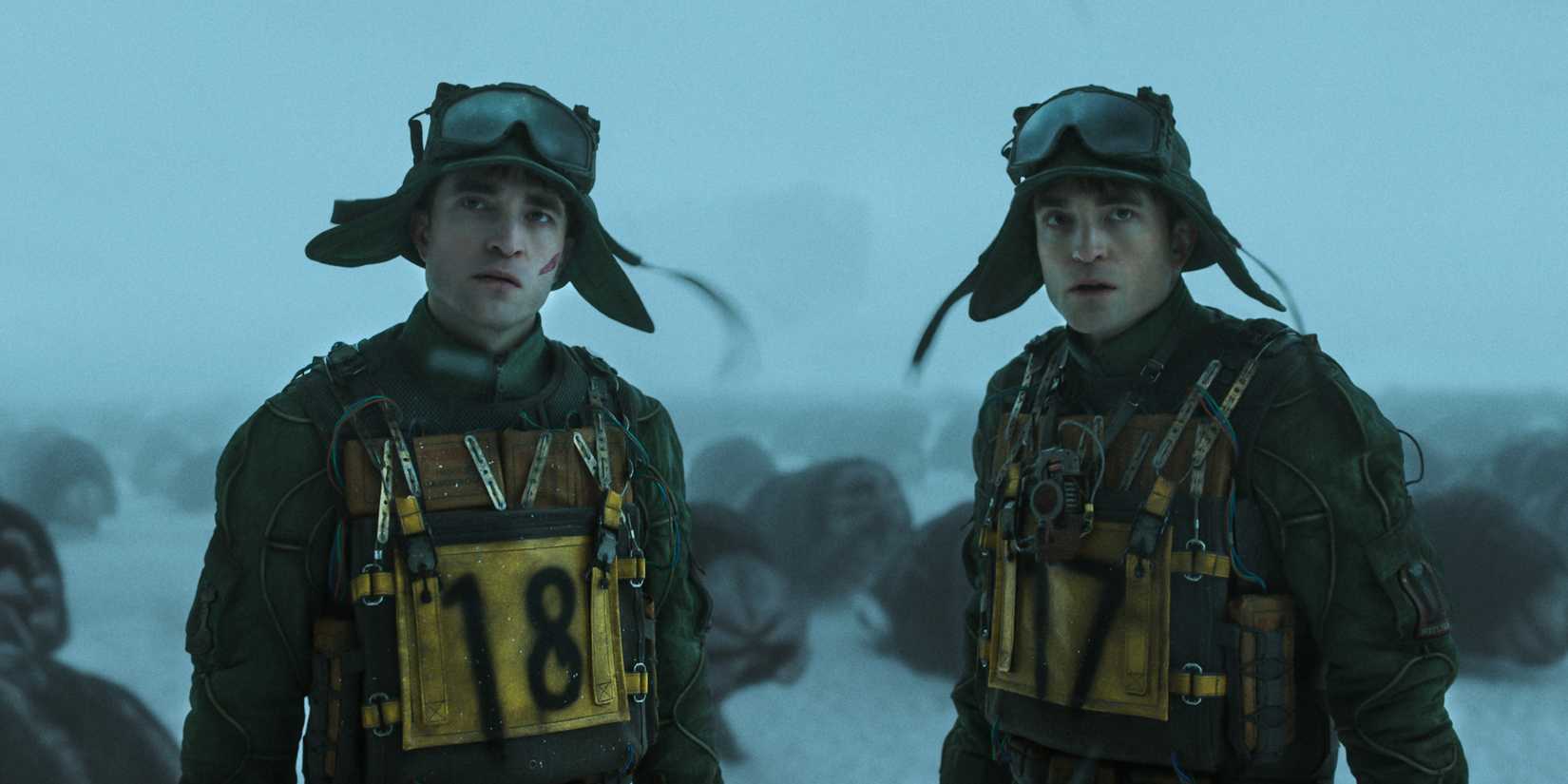 Mickey 17 e 18 lado a lado ao ar livre na neve em Mickey 17