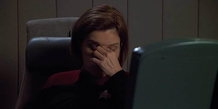 Kate Mulgrew como Janeway, com a mão na testa, em Star Trek: Voyager.